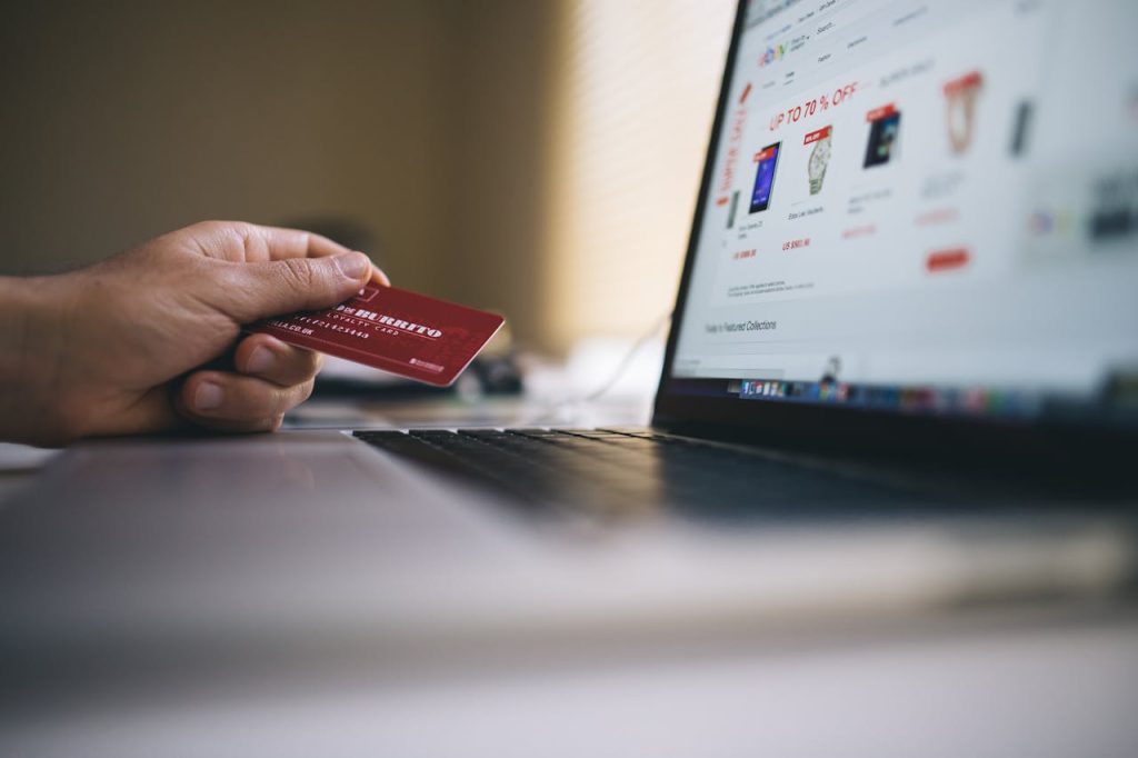 pexels-photo Person holding a credit card while shopping online on a laptop, indicating ecommerce transactions.